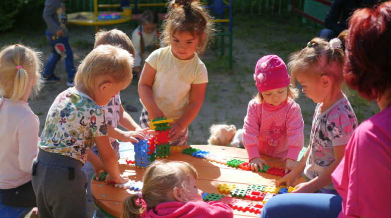 A group of children playing with blocks at a table.